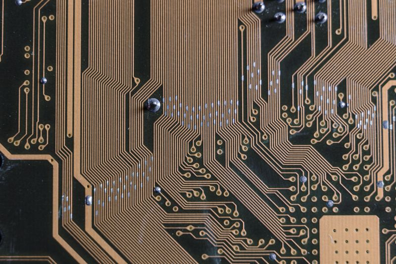 Close-up of a TV main board being repaired at component level