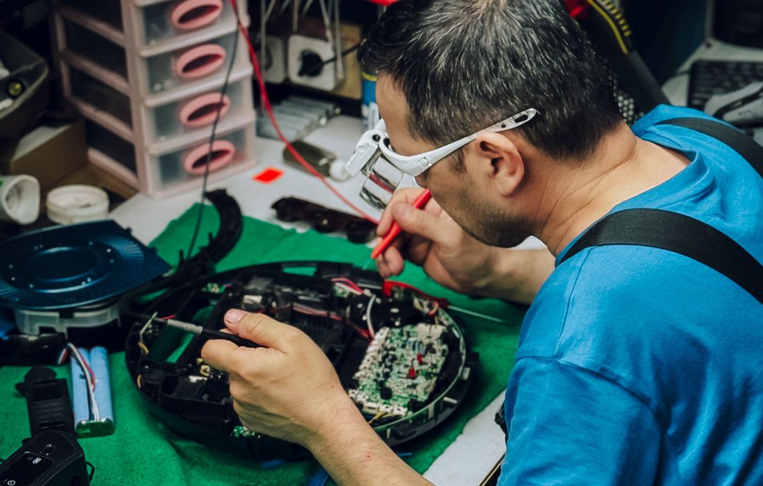 TV repair technician working on electronics at the workshop bench